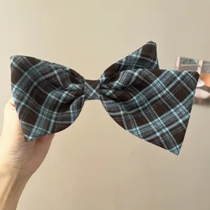 Nahaufnahme eines blau-braun karierten Schleifen-Haarreifens im französischen Retro-Stil