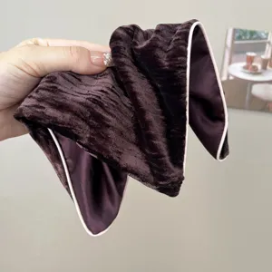Detailed view of dark brown velvet headband featuring contrast piping edge texture.