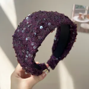 Détail d'un serre-tête en tweed violet avec des paillettes brillantes et style volumineux