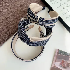 Close-up of stylish wide knotted headband featuring a classic blue plaid fabric pattern