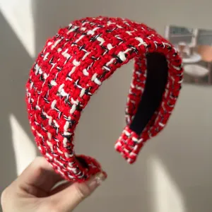 Gros plan d'un serre-tête en tweed rouge et blanc montrant une texture de laine de qualité
