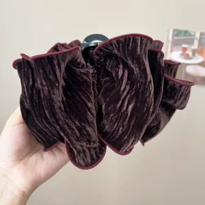 Detailed close-up of a voluminous burgundy velvet scrunchie with soft pleated texture.