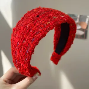 Détail du serre-tête en tweed rouge avec texture bouclée épaisse et doublure noire.