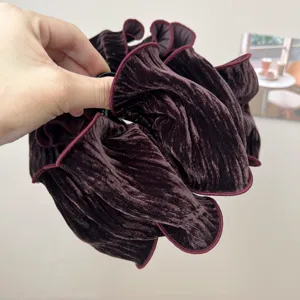 Close-up of a vintage burgundy velvet pleated scrunchie hair tie with rich texture