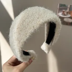 Gros plan détaillé d'un serre-tête en laine beige pelucheuse au design bombé