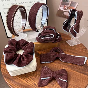 Close-up of elegant burgundy tweed hair accessories with stylish blue piping details.
