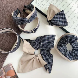 Flat lay of plaid and beige hair accessories set with knotted headbands and scrunchies