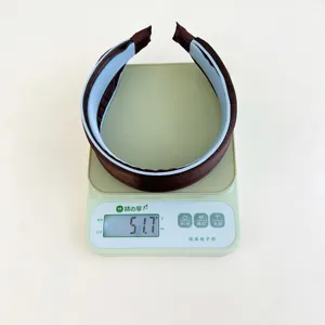 Detail view of the brown wide-brimmed headband showing its weight of 51.7 grams.