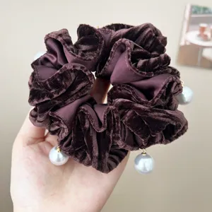 Detail of vintage dark brown velvet scrunchie featuring elegant pearl charms and texture