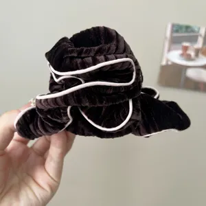 Macro detail view of a dark brown velvet sponge headband with contrasting pink piping