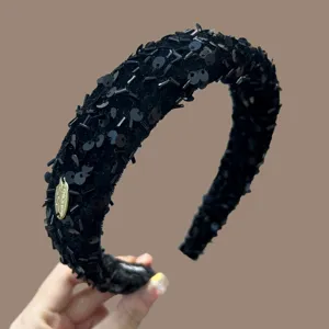 Detailweergave van de elegante zwarte pailletten en kralen op deze gevoerde haarband