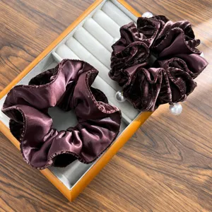 Detailed macro view of dark chocolate brown velvet scrunchies with elegant pearl accents