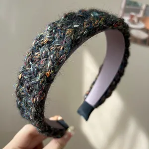 Detailed view of a multicolored woven woolen headband with thick knit texture.