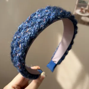 Close-up of navy blue chunky knit headband with colorful flecks and a wide brim design.