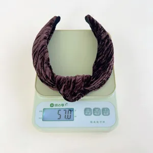 Dark brown velvet headband detail showing weight of 57.0g on a digital scale for accuracy.