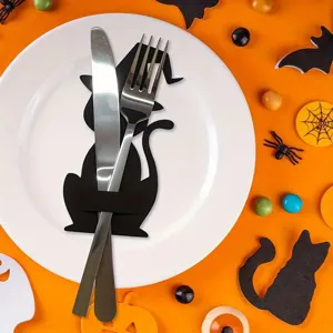 Detail of a black cat felt cutlery holder with witch hat design on a white ceramic plate