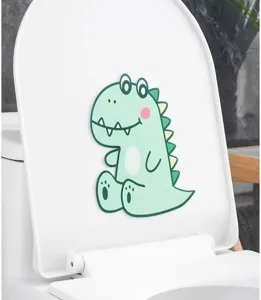 Detail of a green cartoon dinosaur felt deodorizing sticker on a white toilet lid.