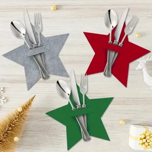 Festive red, green, and grey star-shaped felt cutlery holders arranged on wood