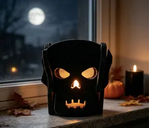 Photophore d'Halloween en feutre noir avec lumière chaude sur un rebord de fenêtre