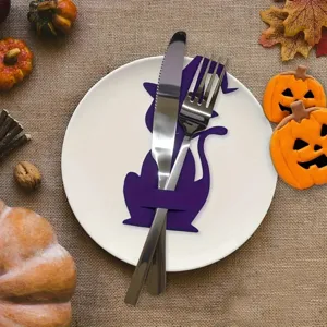 Halloween purple cat cutlery holder on a white plate with festive pumpkin decor.
