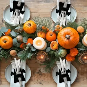 Halloween felt bat cutlery sleeves arranged on a festive dining table with pumpkins