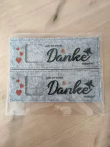 Graue Filzhülle für Schokoriegel mit Danke Aufdruck und Herzmustern.