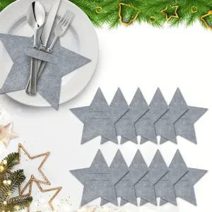 Grey star-shaped felt cutlery holders displayed on a white plate with Christmas decor.
