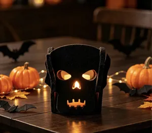 Détail d'un bougeoir d'Halloween en feutre noir avec une lueur de bougie chaleureuse
