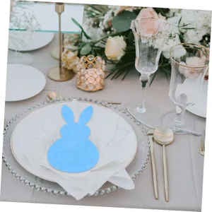 Close-up of a blue rabbit felt cutlery holder on a marble plate table setting