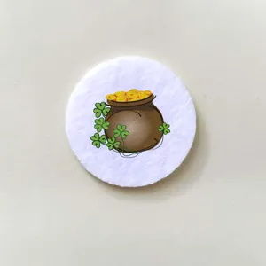 Detailed view of a circular badge featuring a cartoon shamrock and pot of gold design