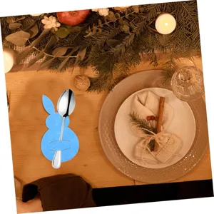 Blue bunny felt cutlery holder with silver spoon on festive Easter dinner table setup