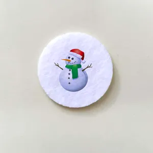 Close-up of a circular white badge featuring a cute cartoon snowman for Christmas gift.