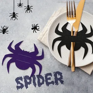 Macro view of Halloween spider-shaped cutlery holder on a white plate with gold utensils