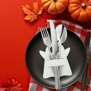 Close-up of white ghost cutlery holder with silver fork, knife, and spoon on black plate.