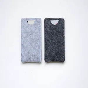 Close-up detail of two minimalist felt card holders in light and dark grey colors