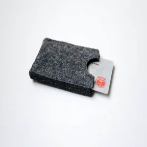 Close-up macro detail of a minimalist gray felt card holder sleeve showing the soft texture