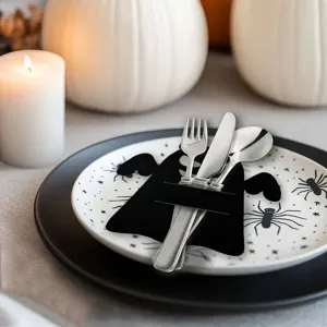 Halloween felt ghost cutlery holder on a spider-patterned plate with pumpkin decor