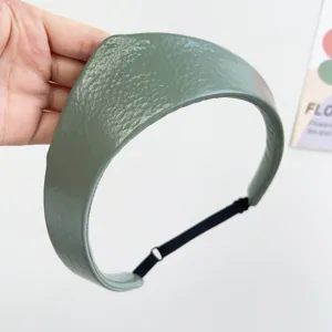 Detailed view of sage green textured leather crown headband with adjustable strap.