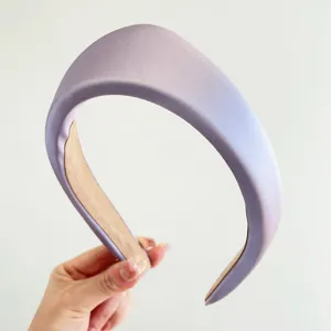 Primer plano de una diadema acolchada de satén lavanda con un elegante estilo retro vintage