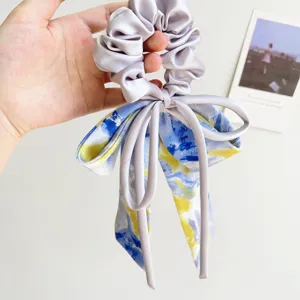 Elegant lavender satin scrunchie featuring a blue and yellow oil painting print bow