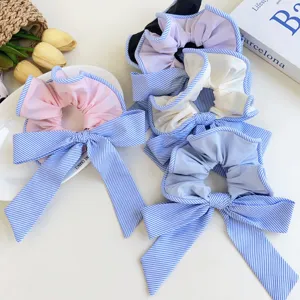 Variedad de coleteros con lazo a rayas en telas de color rosa, azul y crema.