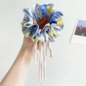 Detailed macro view of a large oil painting tie-dye fabric scrunchie with long ribbons