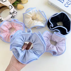 Macro detail of the double-layered striped edge on a blue fabric hair scrunchie
