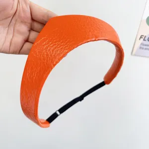 Close-up of orange leather crown headband with textured finish and adjustable strap