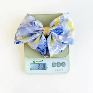 Detail shot of elegant oil-painted smudge bow hair clip weighing 37.8g on a precision scale
