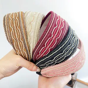 Primo piano dettagliato di cinque fasce per capelli larghe con perline in colori assortiti.