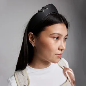 Detailed side view of a black vintage headband with silver rings worn by a model