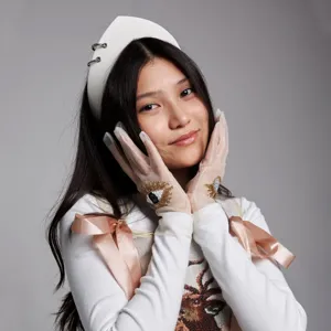 Detail view of a retro white velvet headband with metal rings worn by an Asian model