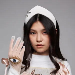 Close-up detail of a white vintage pointed headband with distinctive metal ring accents