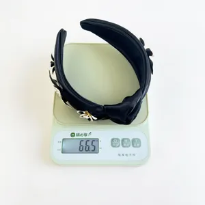 Vue détaillée montrant le poids de 66,5g du serre-tête en satin noir à fleurs en métal